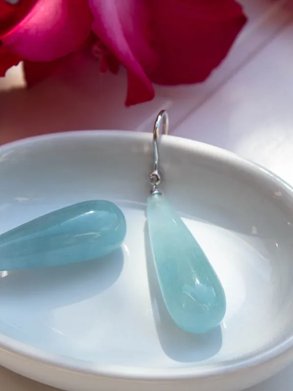 Boucles d’oreilles en gouttes de pierre bleue, posées dans une coupelle