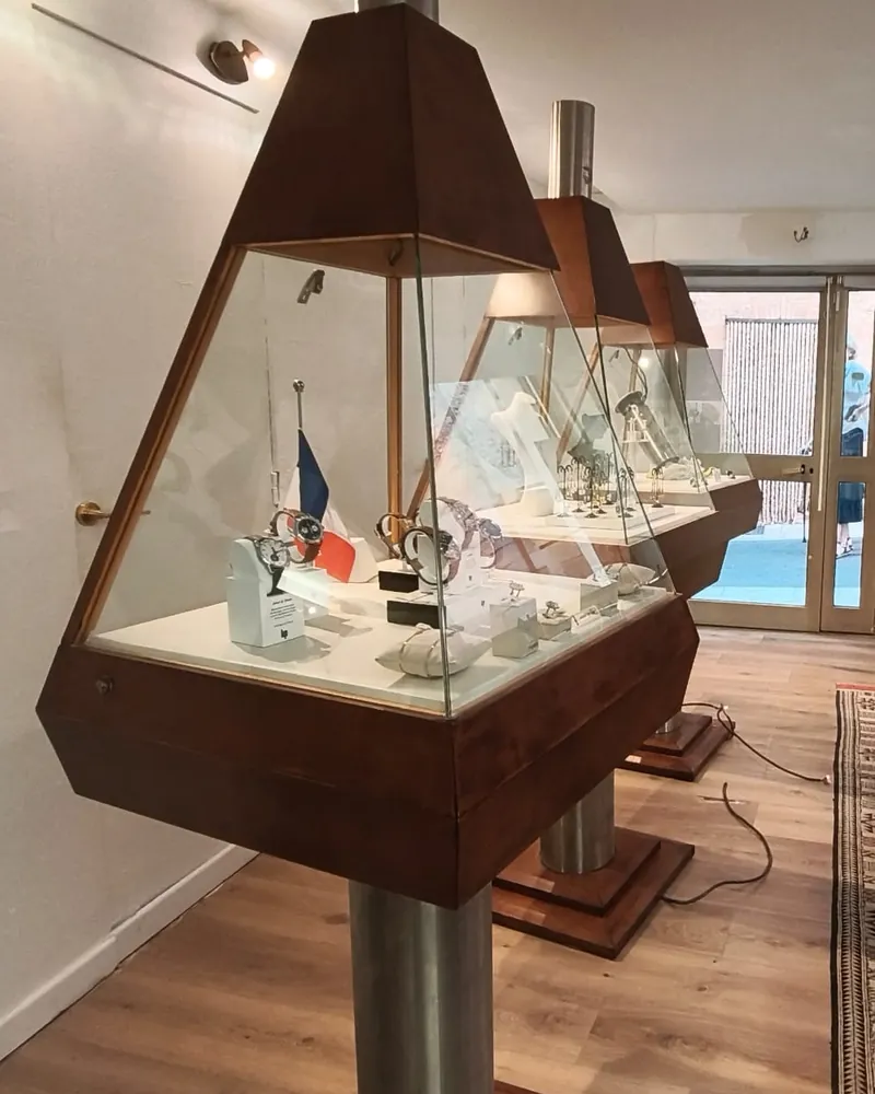 Montres présentées dans les vitrines en bois de la boutique Aiôn